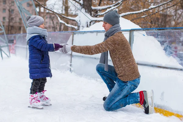 Entzückendes kleines Mädchen und glücklicher Papa auf der Eisbahn im Freien — Stockfoto