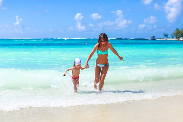 Joven madre feliz y adorable hija divirtiéndose en la playa exótica en el día soleado —  Fotos de Stock