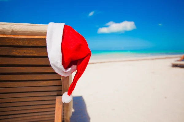 Roter Weihnachtsmannhut auf Stuhllehne am tropischen Karibikstrand — Stockfoto