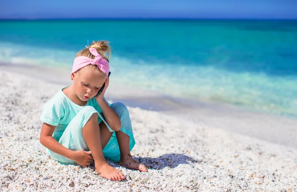 Kleines entzückendes Mädchen telefoniert während des Strandurlaubs — Stockfoto