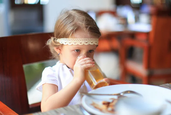 Entzückendes kleines Mädchen frühstückt im Restaurant — Stockfoto