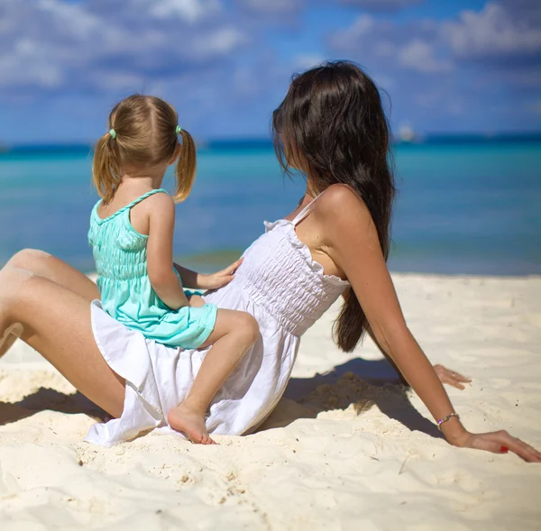 年轻的快乐妈妈和可爱的女儿在异国风情的沙滩上阳光明媚的日子开心 — 图库照片