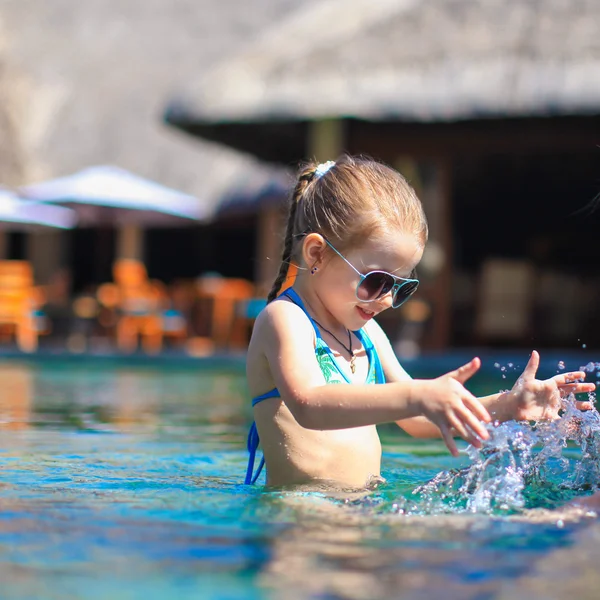 Klein schattig gelukkig meisje in zwembad tijdens de zomervakantie — Stockfoto