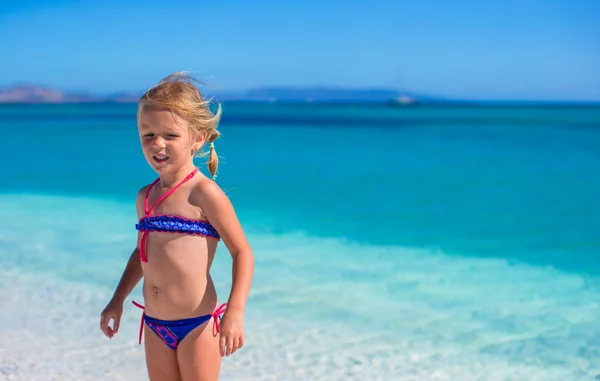 Little girl having fun enjoying vacation on tropical beach with white sand and turquoise ocean water — Stock Photo, Image