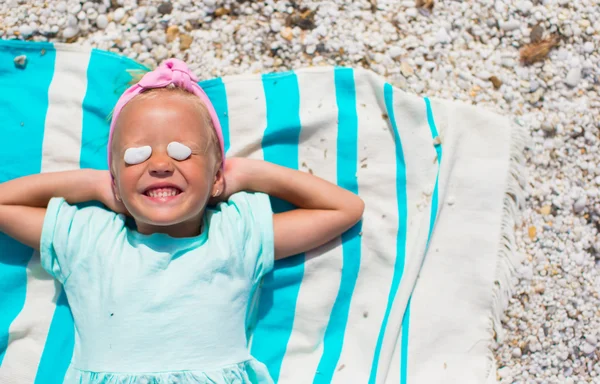 Adorable little girl have fun on towel at white beach — Stock Photo, Image