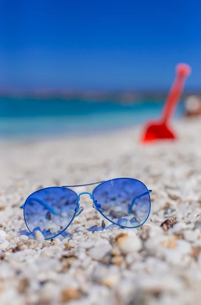 Close up van kleurrijke blauwe zonnebril op tropisch strand — Stockfoto