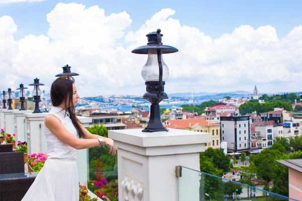 Young woman on terrace with stunning view of the city — Stock Photo, Image