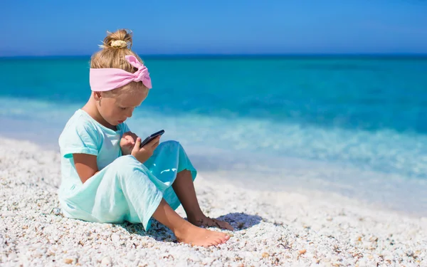 Schattig meisje fotograferen op telefoon op tropisch strand — Stockfoto