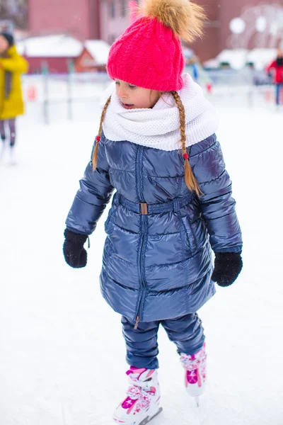 可爱的小女孩在户外溜冰场上溜冰 — 图库照片