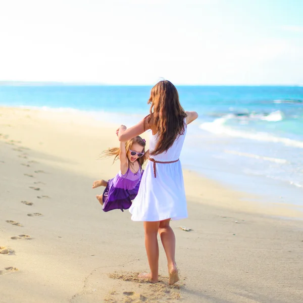 Joven madre feliz y adorable hija divirtiéndose en la playa exótica en el día soleado —  Fotos de Stock