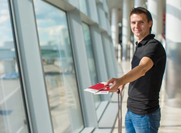 Homme titulaire d'un passeport et d'une carte d'embarquement à l'aéroport attendant le vol — Photo