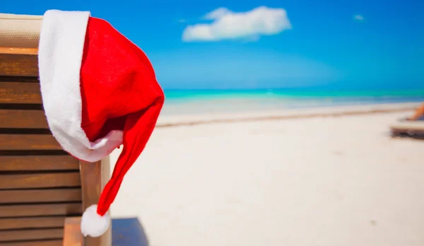 Roter Weihnachtsmannhut auf Stuhllehne am tropischen Karibikstrand — Stockfoto