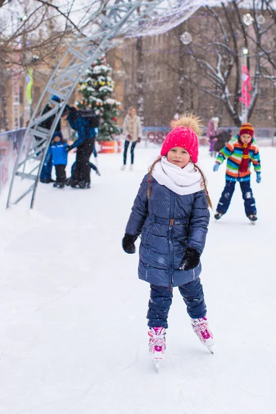 Entzückendes kleines Mädchen beim Schlittschuhlaufen auf der Eisbahn — Stockfoto