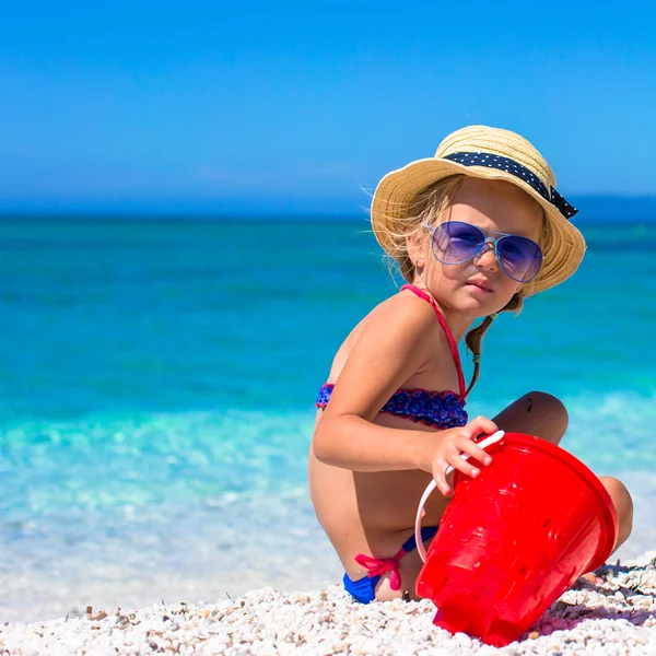Adorable little girl playing with beach toys during tropical vacation — Stock Photo, Image