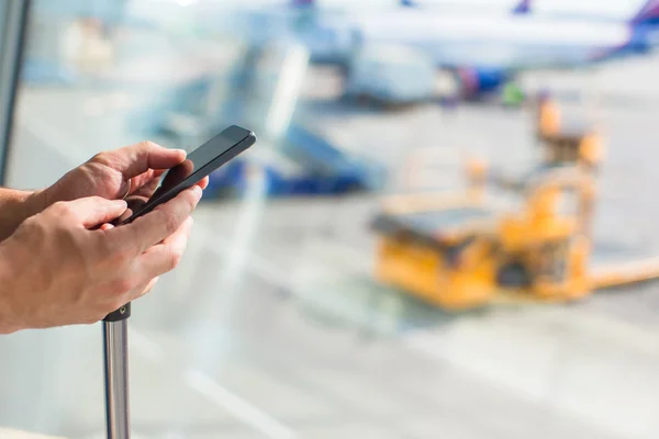 Dicht tot mans handen met behulp van mobiele telefoon binnen luchthaven — Stockfoto