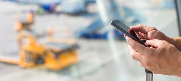 Закрыть руки людей с помощью мобильного телефона в аэропорту
