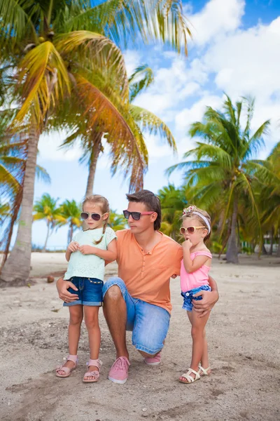 Papá joven y lindas hijas en palmeral durante las vacaciones en la playa —  Fotos de Stock