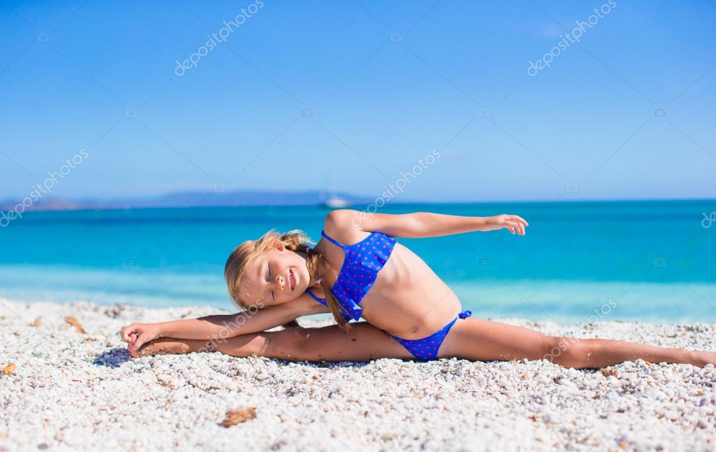 Happy little sporty girl on white tropical beach