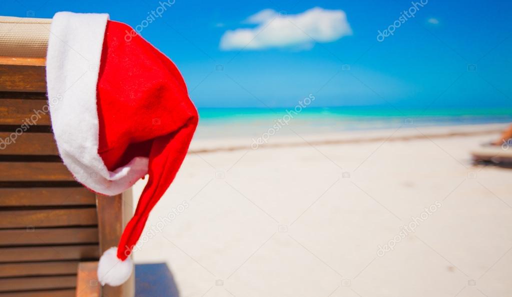 Red santa hat on chair longue at tropical caribbean beach