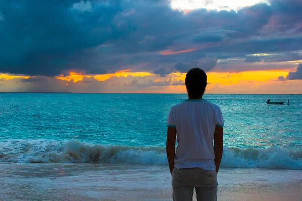 Young man enjoying sunset during beach vacation — Stock Photo, Image