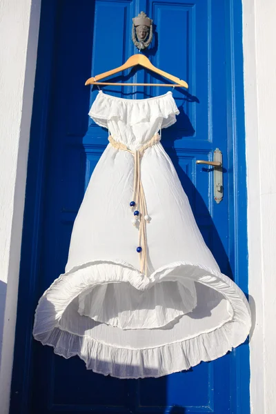 White dress on blue door in greek house — Stock Photo, Image