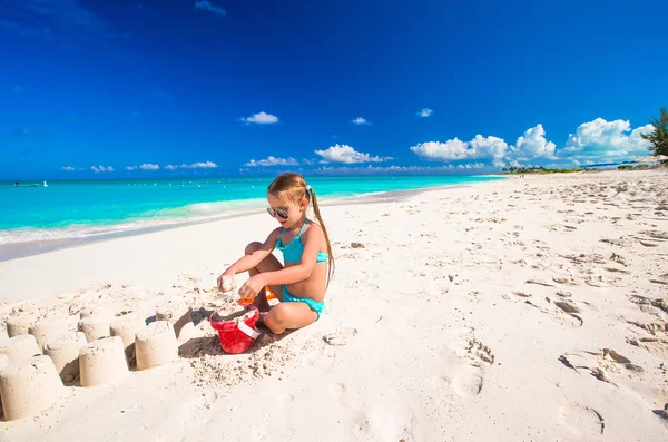 Adorável menina brincando com brinquedos durante as férias na praia — Fotografia de Stock