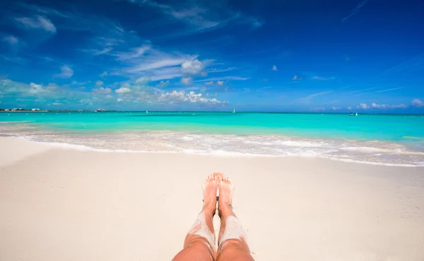 Zblízka ženské nohy na bílé písečné pláži — Stock fotografie