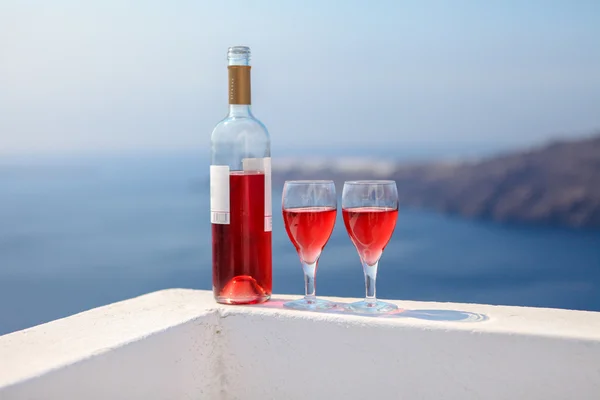 Two glasses and bottle of tasty red wine at sunset in Greece — Stock Photo, Image