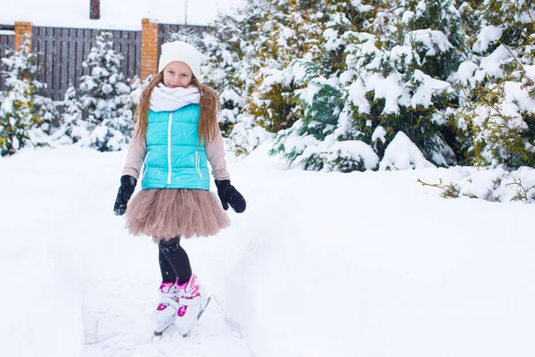 Bedårande liten flicka skridskor i vinter snö dag utomhus — Stockfoto