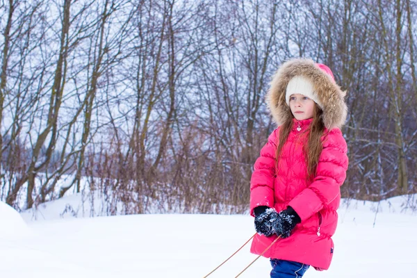 Menina indo trenó no dia de inverno nevado — Fotografia de Stock