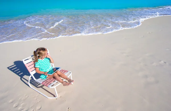 Αξιολάτρευτο κοριτσάκι με το laptop στην παραλία κατά τη διάρκεια των θερινών διακοπών — Φωτογραφία Αρχείου