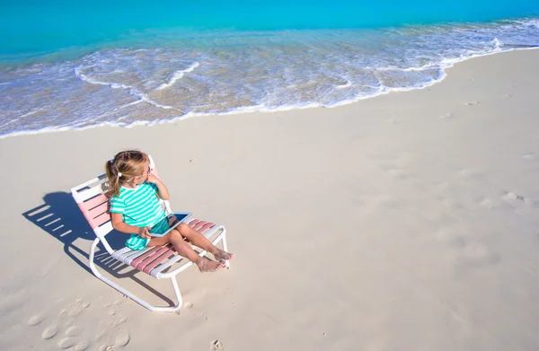 Liten bedårande flicka med laptop på stranden under sommarlovet — Stockfoto