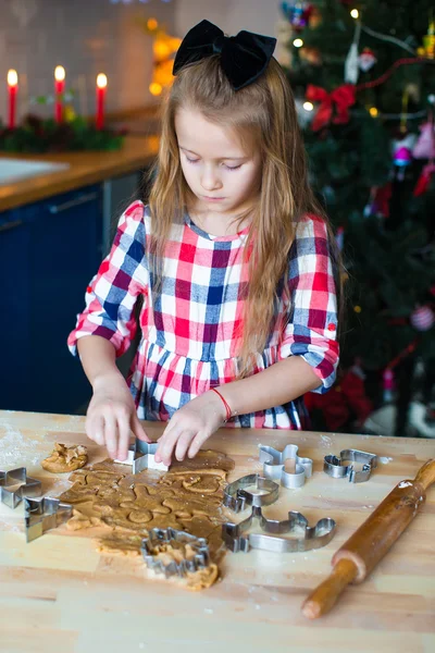 少女の家庭の台所にクリスマスのジンジャーブレッドのクッキーを焼く — ストック写真
