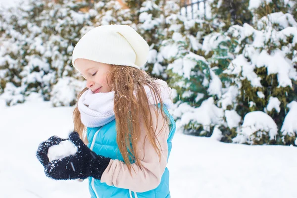 Happy adorable girl playing snowballs in snowy winter day — Stock Photo, Image