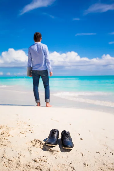 Giovane con computer portatile durante le vacanze al mare tropicale — Foto Stock