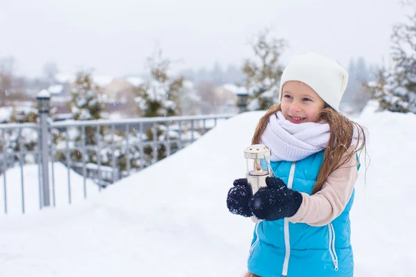 Adorable petite fille tenant lanterne de Noël en plein air par belle journée de neige d'hiver — Photo