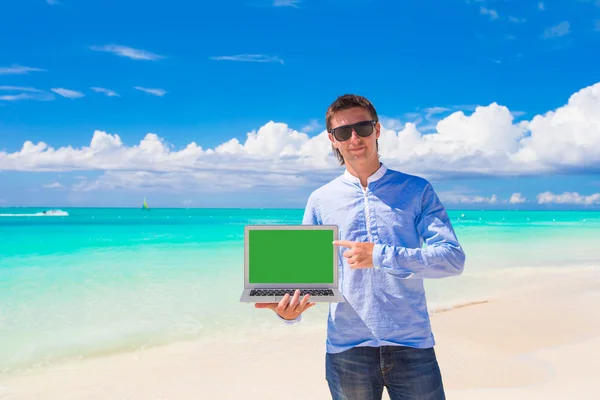 Ung man med laptop under strandsemester — Stockfoto