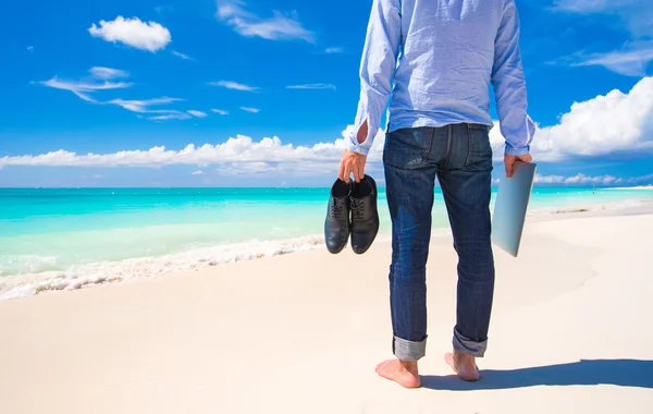 Hombre joven con portátil durante las vacaciones en la playa tropical —  Fotos de Stock