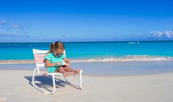 Bambina con computer portatile sulla spiaggia durante le vacanze estive — Foto Stock