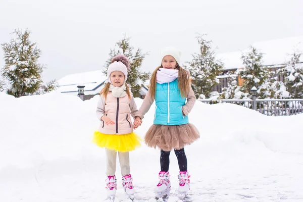 Underbara små flickor skridskor på ishall utomhus i vinter snö dag — Stockfoto