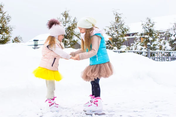 Niñas patinando en pista de hielo al aire libre en invierno día de nieve —  Fotos de Stock