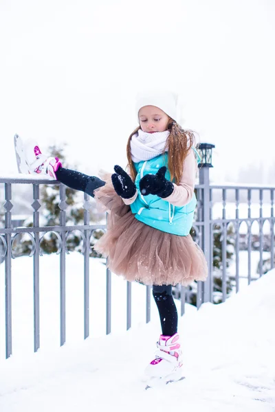 Adorable petite fille patinant sur la patinoire à l'extérieur en hiver journée de neige — Photo