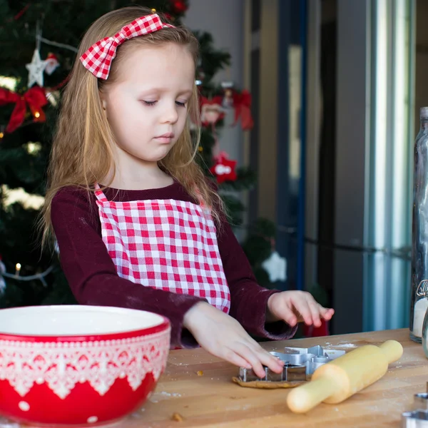 少女の家庭の台所にクリスマスのジンジャーブレッドのクッキーを焼く — ストック写真