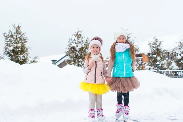 Petites filles heureuses patinant en plein air en hiver journée de neige — Photo