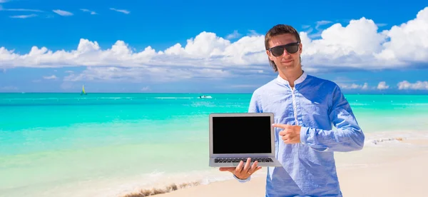 Ung man med laptop under strandsemester — Stockfoto