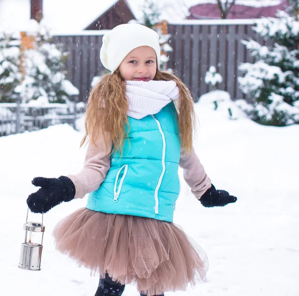 Adorable little girl holding Christmas lantern outdoors on beautiful winter snow day — Stock Photo, Image