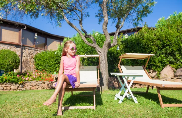 Adorable little girl on beach lounger outdoors — Stock Photo, Image