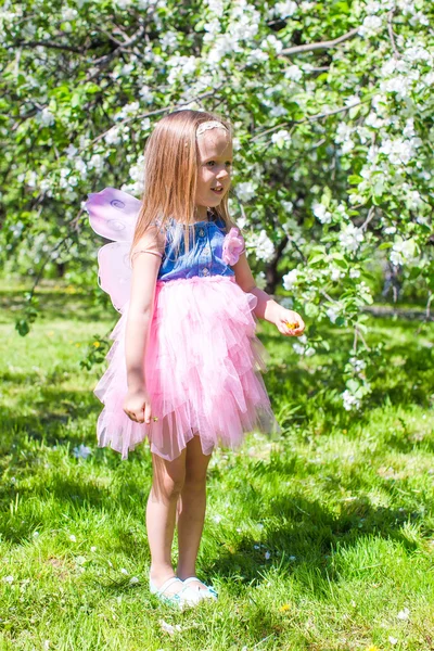 Söt liten flicka i blommande äppelträd trädgård på våren dag — Stockfoto