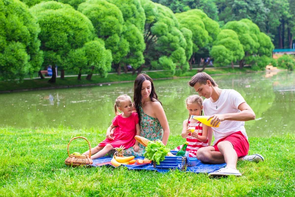 Happy young family picnicking outdoors — Stock Photo, Image