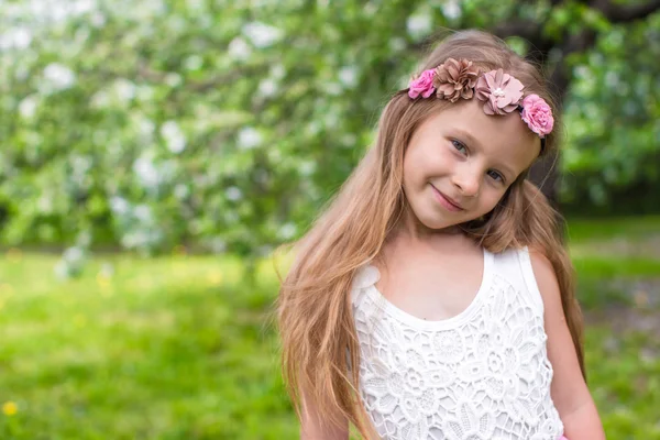 Retrato de pequena menina adorável no jardim de maçã florescente — Fotografia de Stock